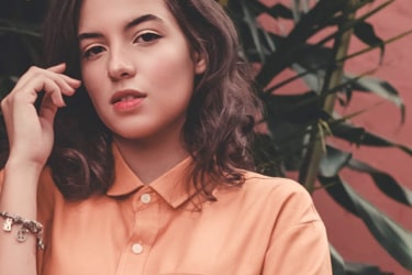 A woman wearing an orange blouse and a bracelet