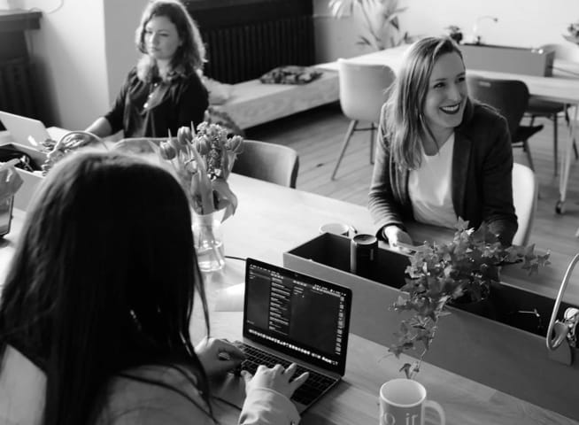 Women sitting around a table working on their laptops